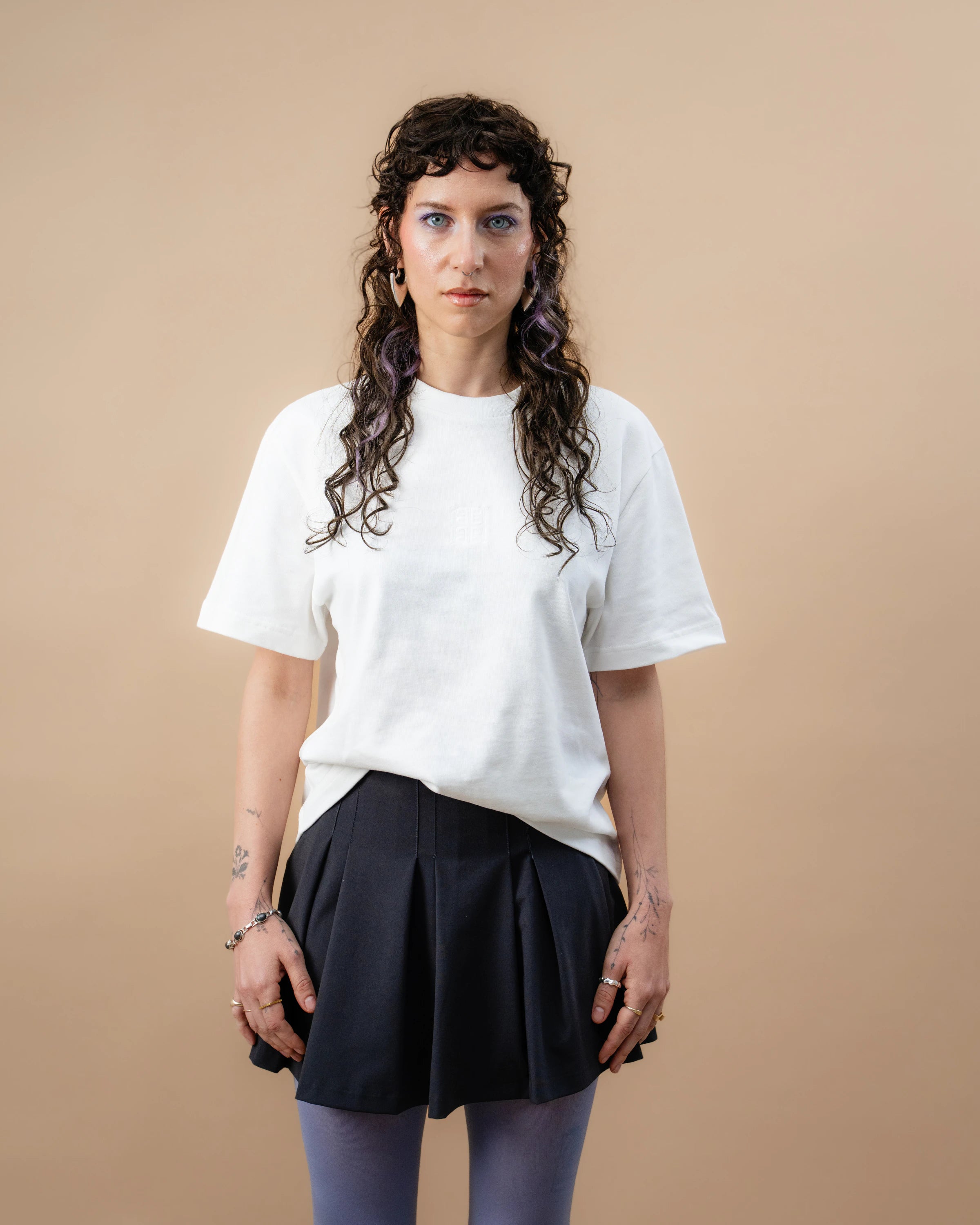Model wears an oversized white Biweekly T-shirt with white ‘BiBi’ logo, front view against a beige background