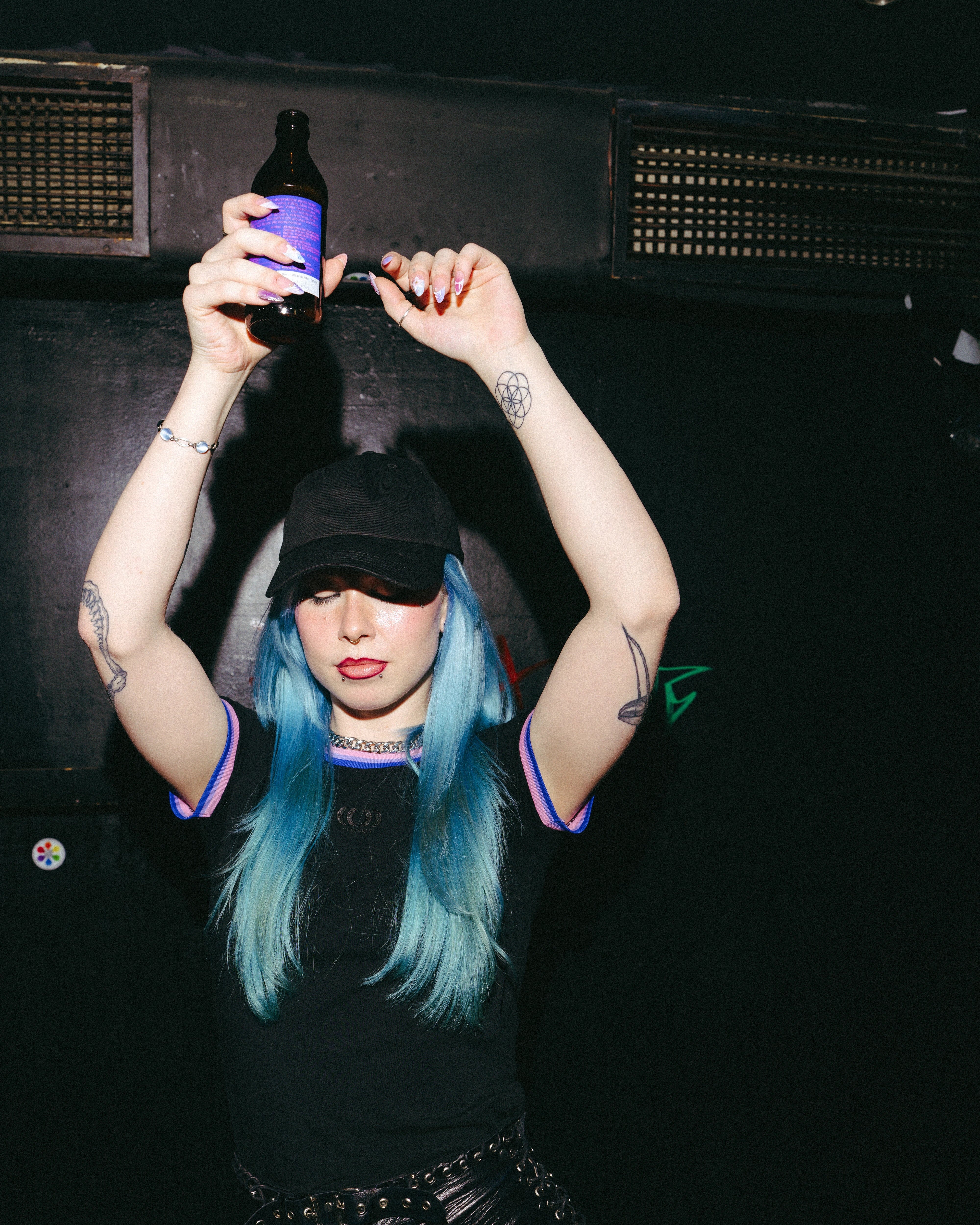 Model wearing a black Biweekly cap, front view, dancing in a club scenario