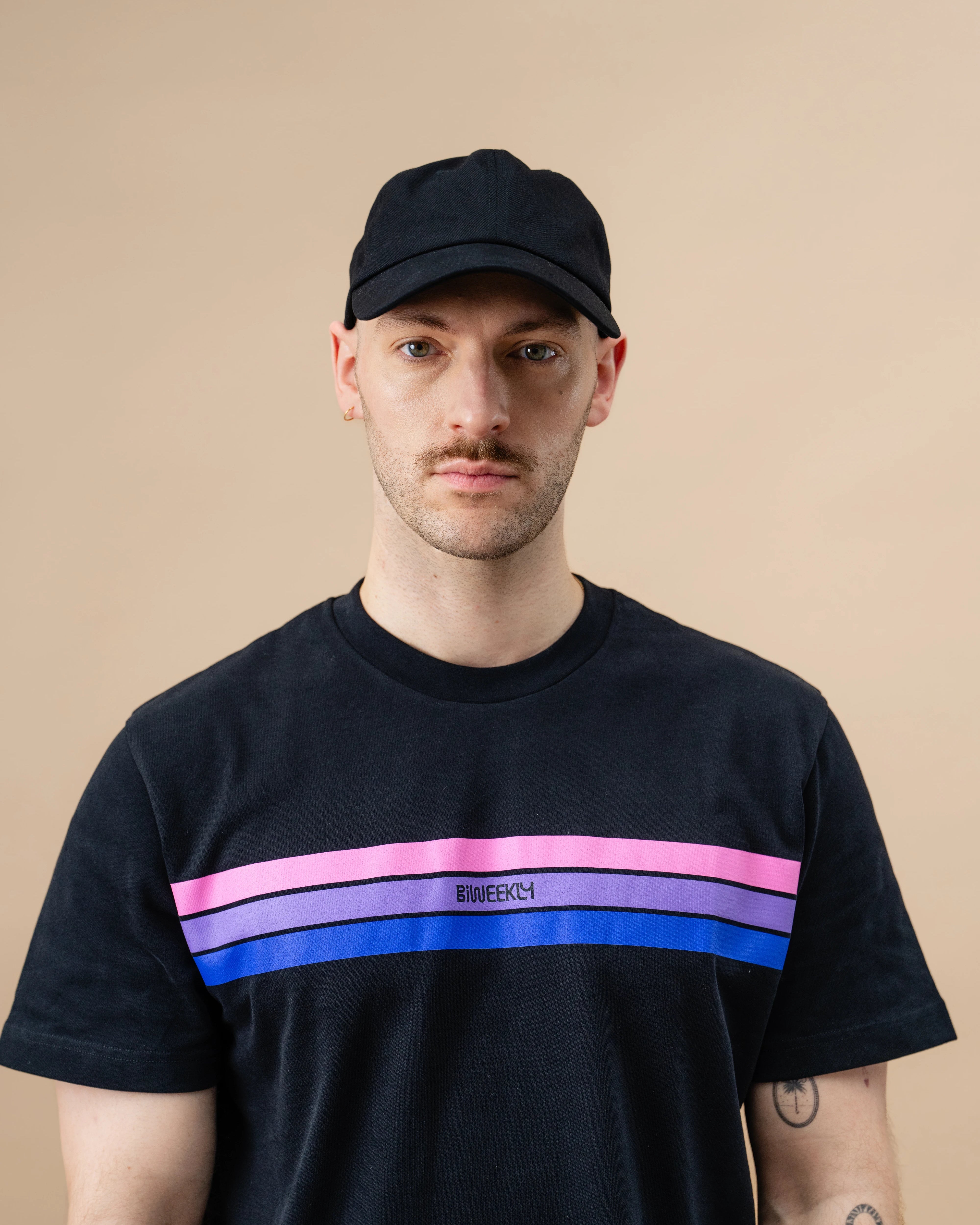 Model wearing a black Biweekly cap against a beige background