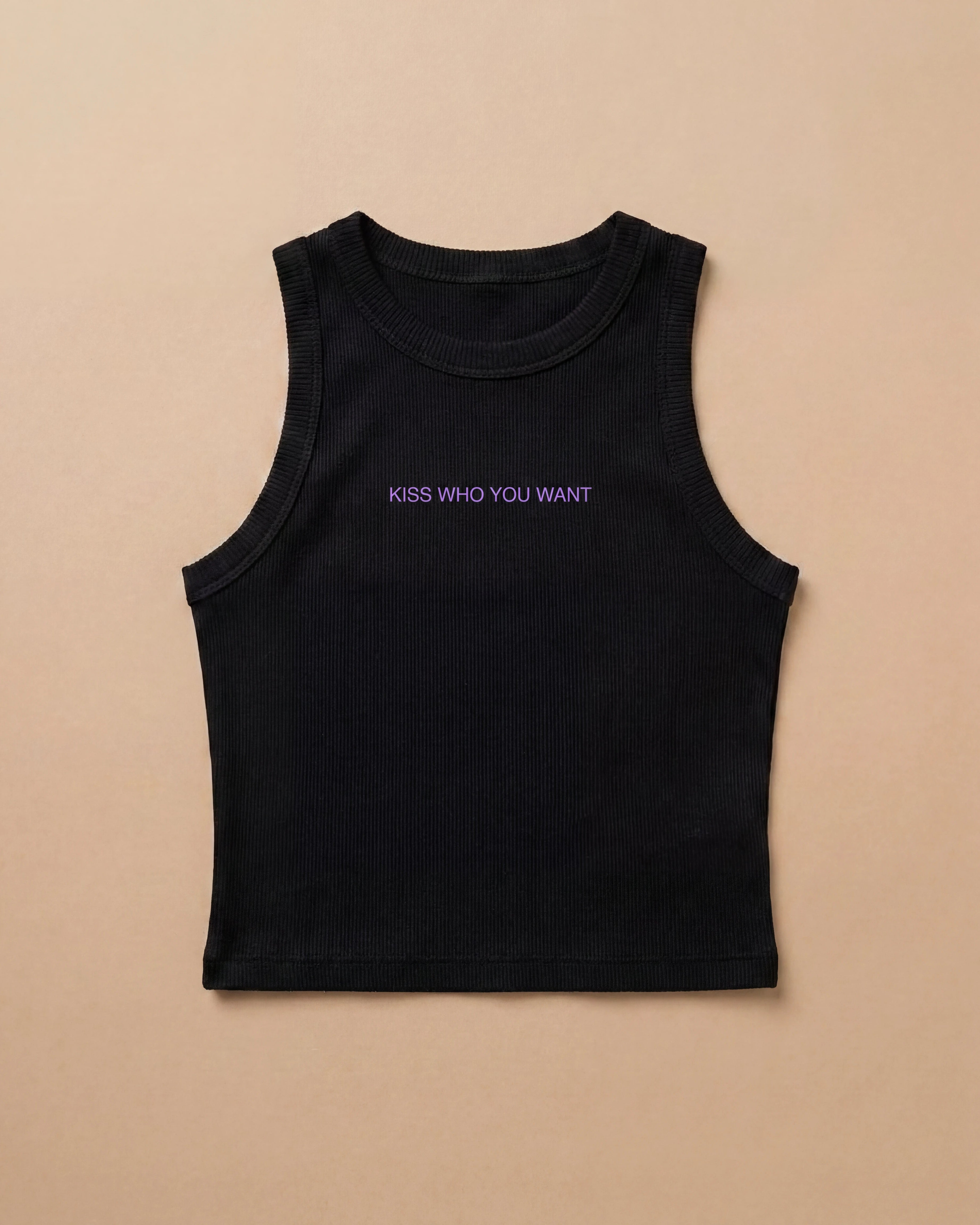 Black Biweekly tank top with lilac ‘Kiss Who You Want’ text, laying flat against a beige background