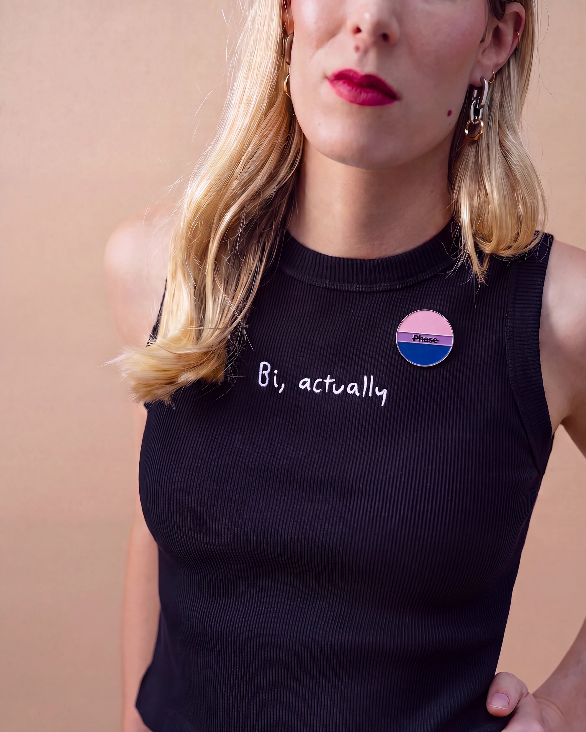 Model is wearing Biweekly Pin in bi colours with a crossed out 'Phase' text on a black Biweekly Crop Top