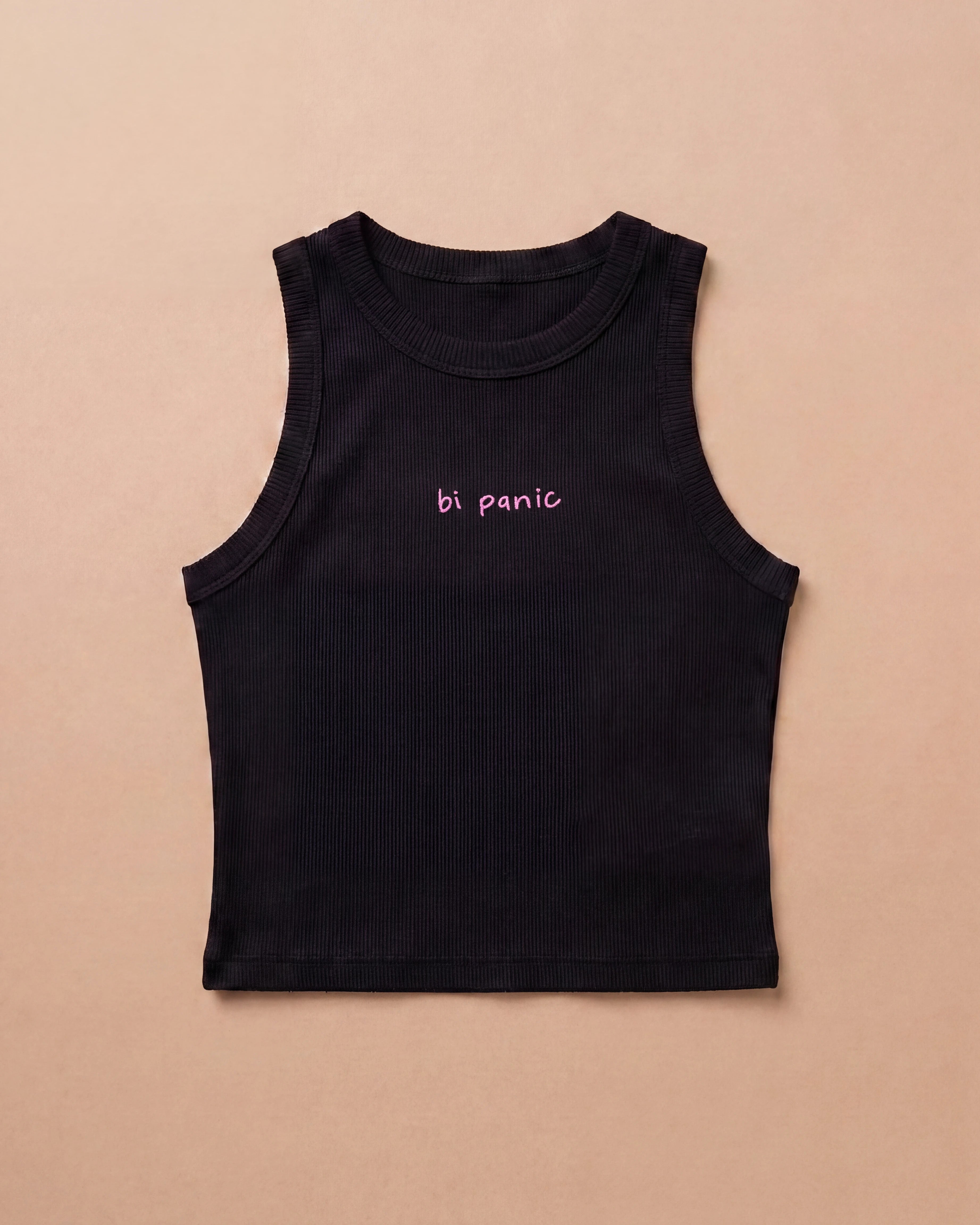 Black Biweekly tank top with pink ‘bi panic’ text, laying flat against a beige background