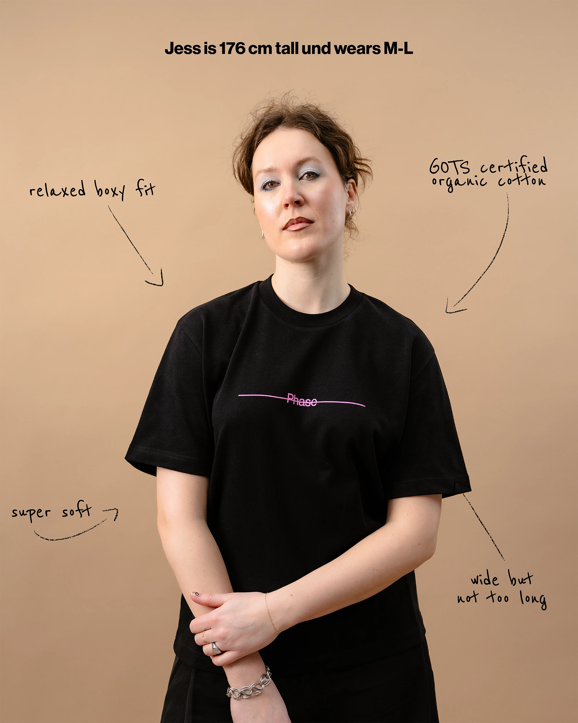 Model wears an black Biweekly T-shirt with a moon phase print that has gradient bi pride colours, front view against a beige background. With text that gives information on the shirt.