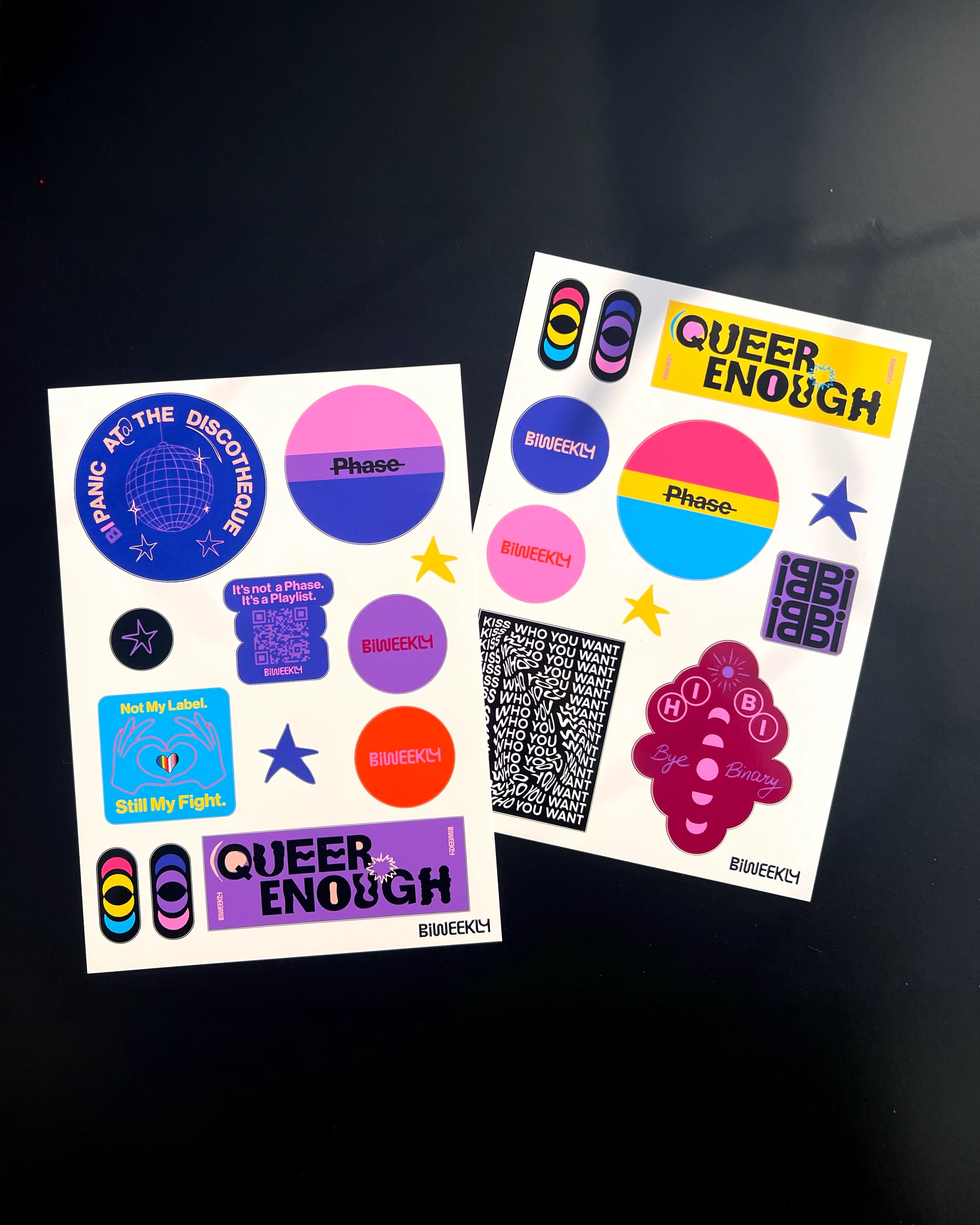 Two stickersheets with 11 and 12 queer-coded stickers in colors of the bi and pan flag and beige, coral and burgundy on black background