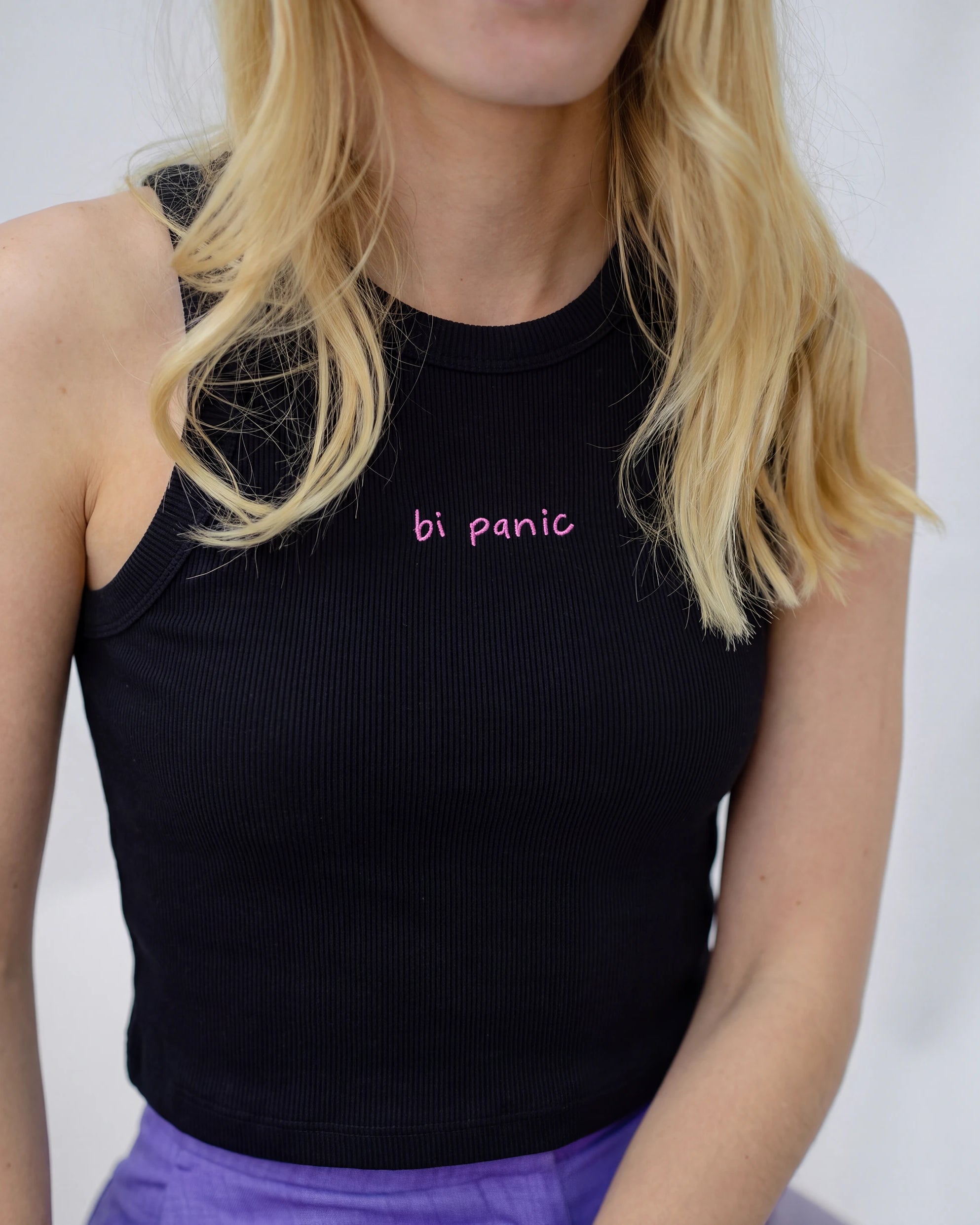 Detail view of a black Biweekly tank top with pink ‘bi panic’ text against white background