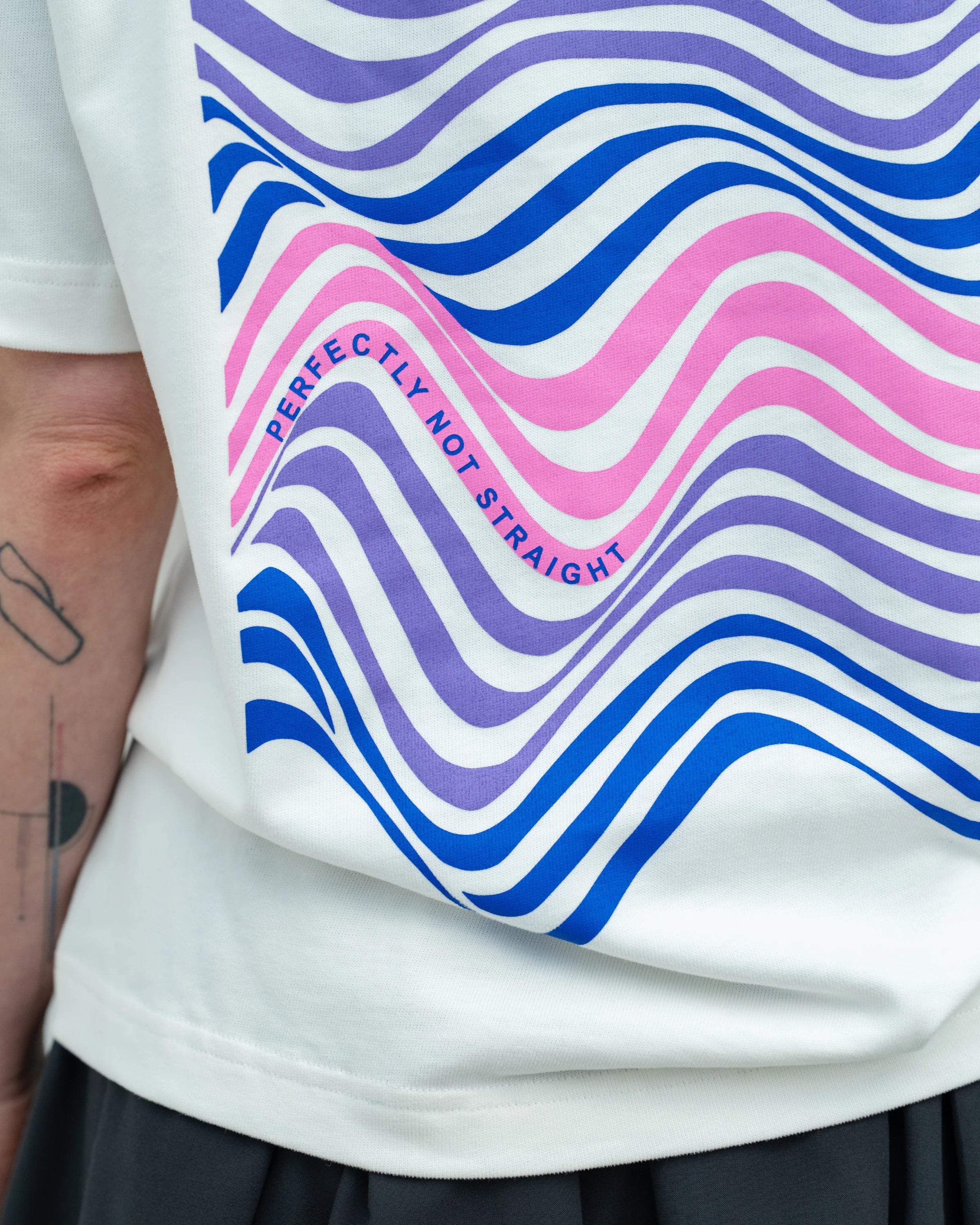 Detailshot of an oversized white Biweekly T-shirt with wavy bi pride flag graphic print and `Perfectly Not Straight` text on the print, back view 