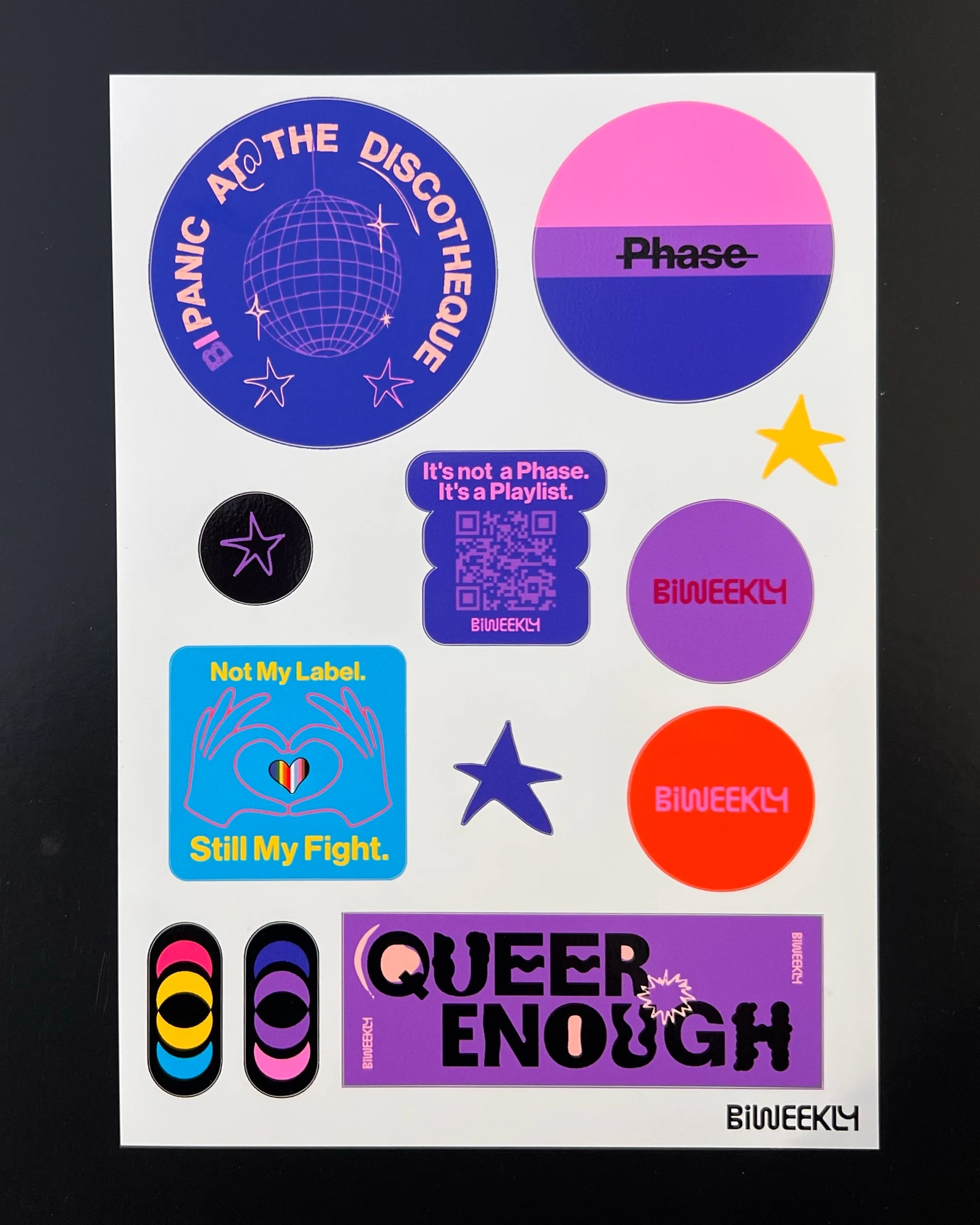 Stickersheet with 12 queer-coded stickers in colors of the bi and pan flag and beige, coral and burgundy on black background