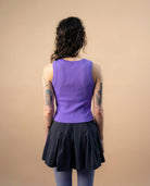 Model wearing a lilac Biweekly tank top, back view against a beige background
