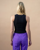 Model wearing a black Biweekly tank top, back view against a beige background