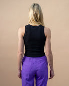 Model wearing a black Biweekly tank top, back view against a beige background