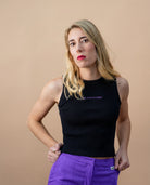 Model wearing a black Biweekly tank top with lilac ‘Kiss Who You Want’ text, front view against a beige background
