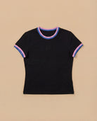 Black Biweekly babytee with bi pride flag trim on the collar and sleeves and black logo in the front, laying flat against a beige background