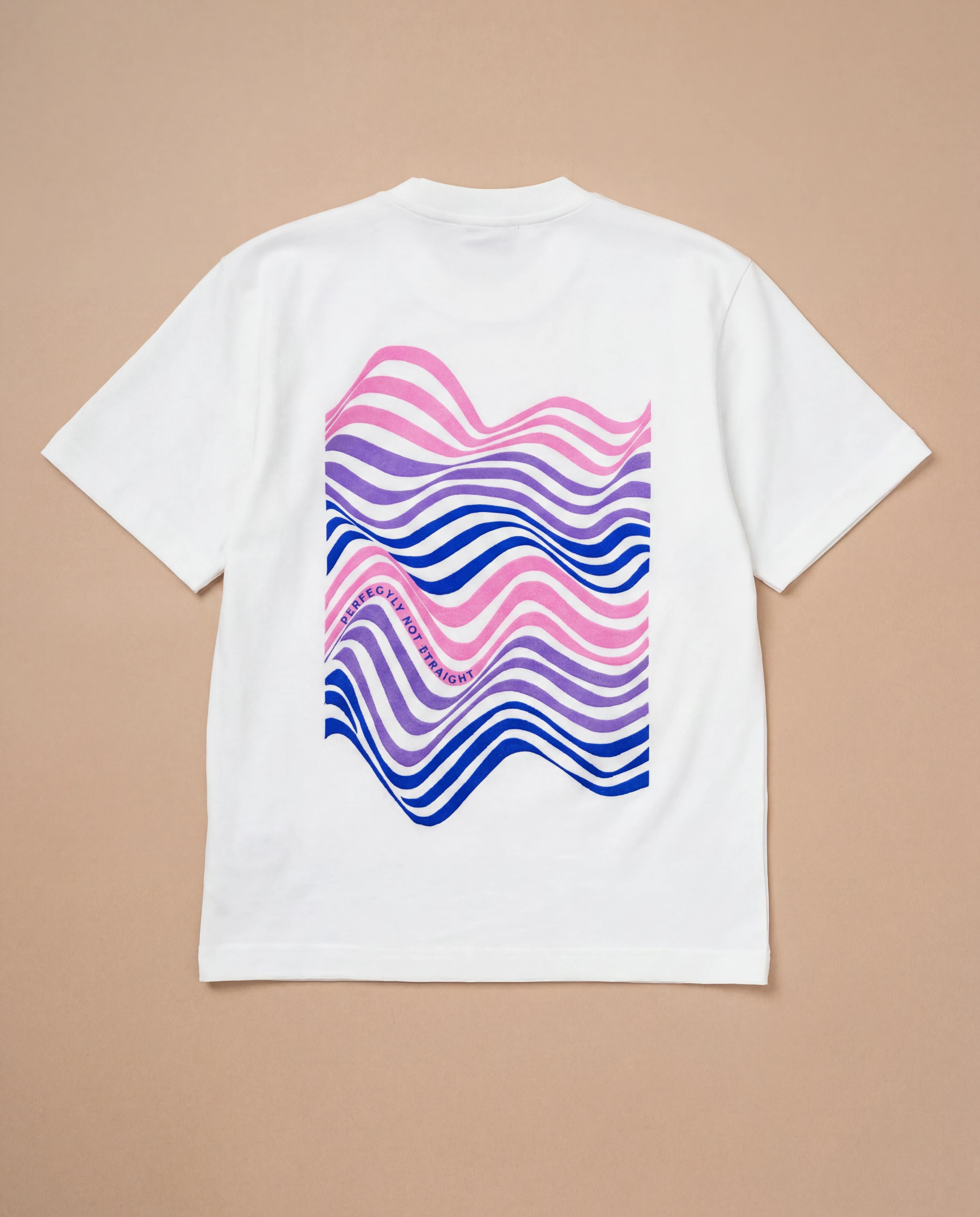 Oversized white Biweekly T-shirt with wavy bi pride flag graphic print and `Perfectly Not Straight` text on the wave print, back view, laying flat on a beige background