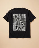 Black oversized Biweekly T-shirt with distorted repeated ‘Kiss Who You Want’ text print, back view, laying flat against a beige background