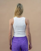 Model wearing a white Biweekly tank top, back view against a beige background