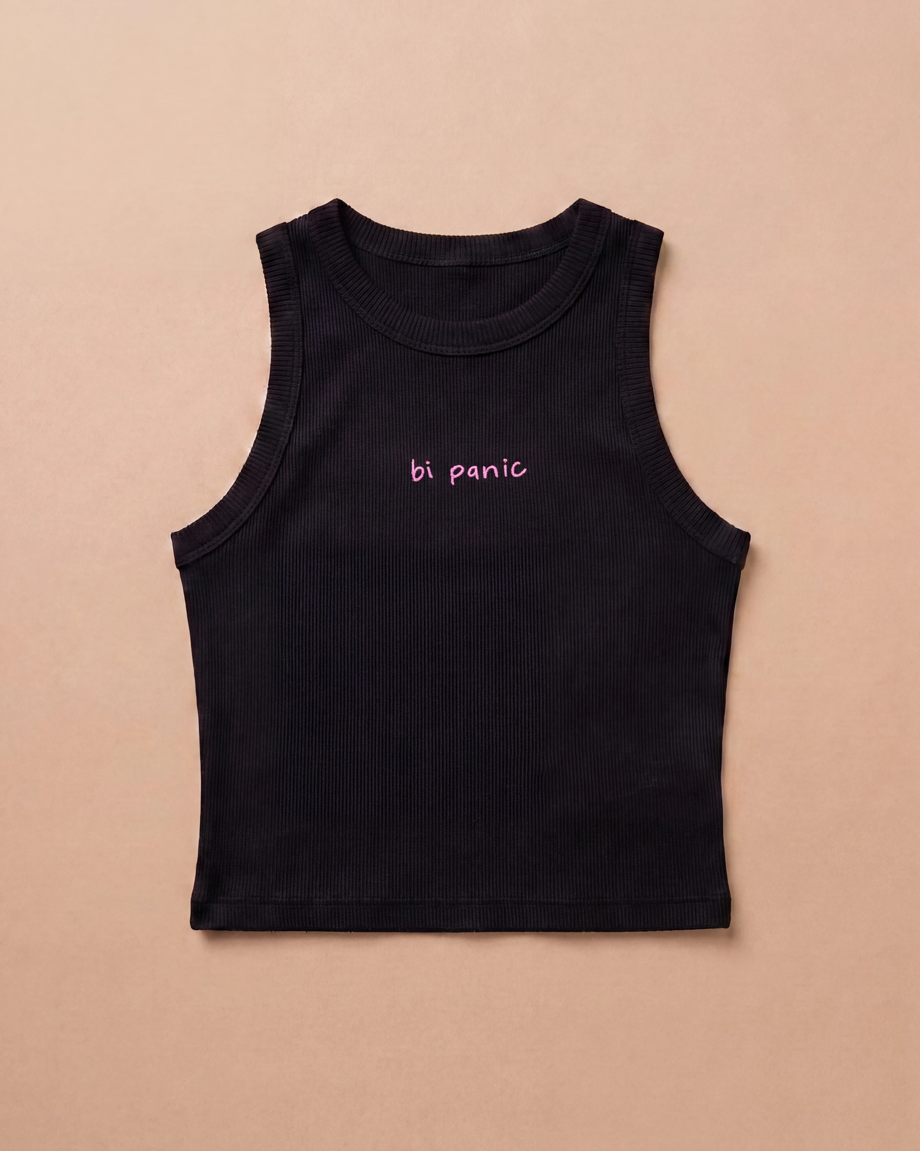Black Biweekly tank top with pink ‘bi panic’ text, laying flat against a beige background