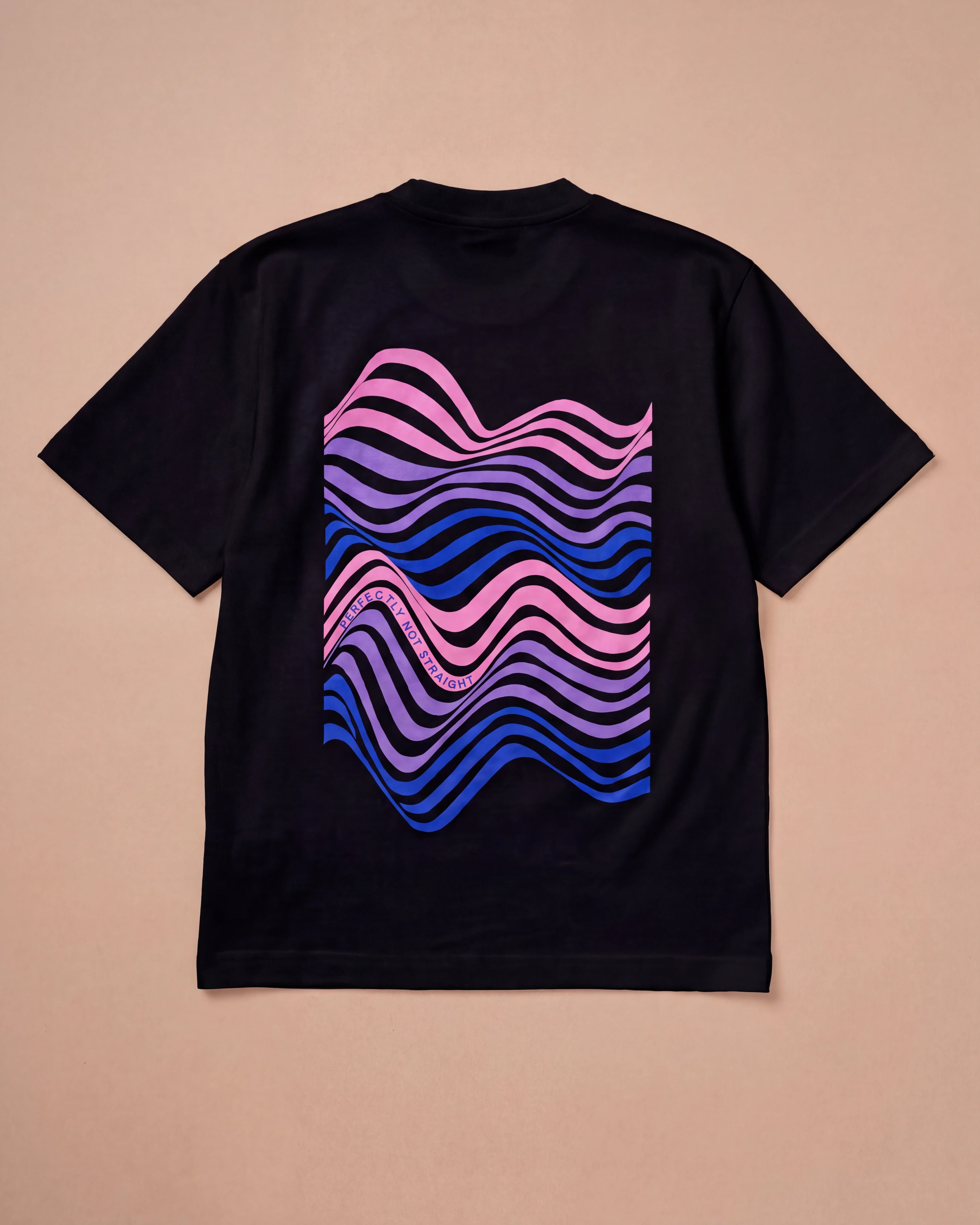 Oversized black Biweekly T-shirt with wavy bi pride flag graphic print and `Perfectly Not Straight` text on the wave print, back view, laying flat on a beige background