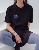 Blue Biweekly pin with 'Bipanic at the discotheque' text and disco ball illustration on a black Biweekly shirt
