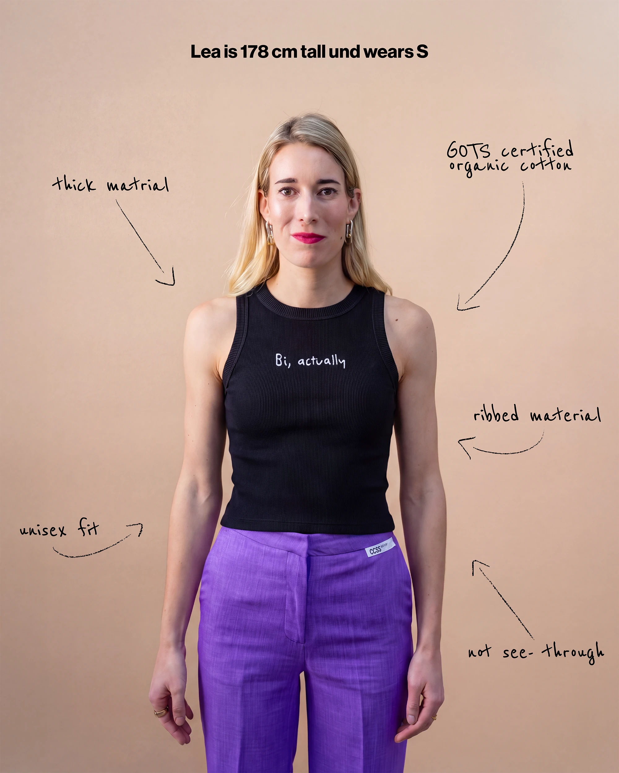 Model wearing a black Biweekly tank top with white ‘Bi, actually’ text, front view against a beige background. Text that gives information about top. 