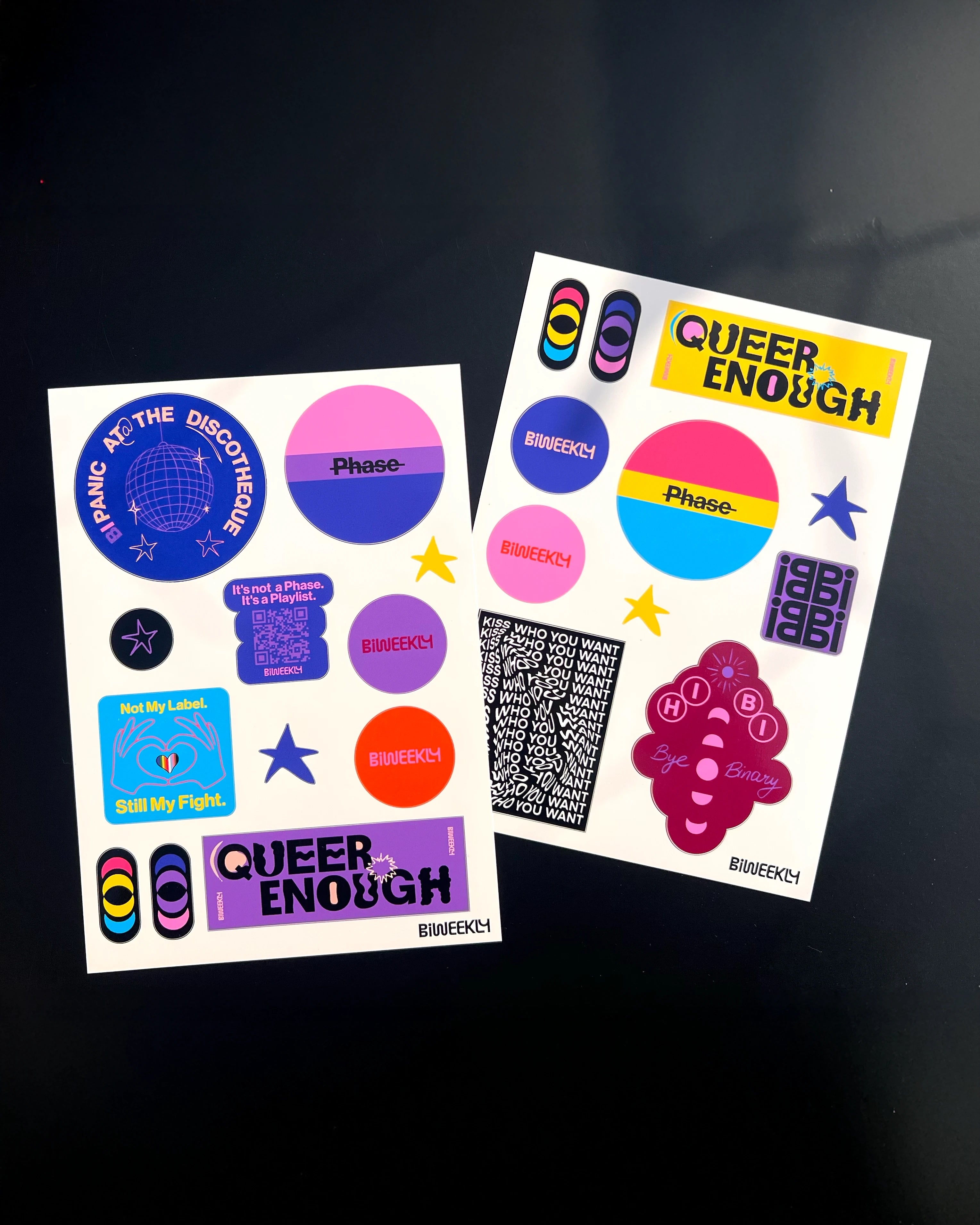 Two stickersheets with 11 and 12 queer-coded stickers in colors of the bi and pan flag and beige, coral and burgundy on black background 