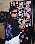 Model wearing an oversized black Biweekly T-shirt with a bi coloured wave print in a club setting
