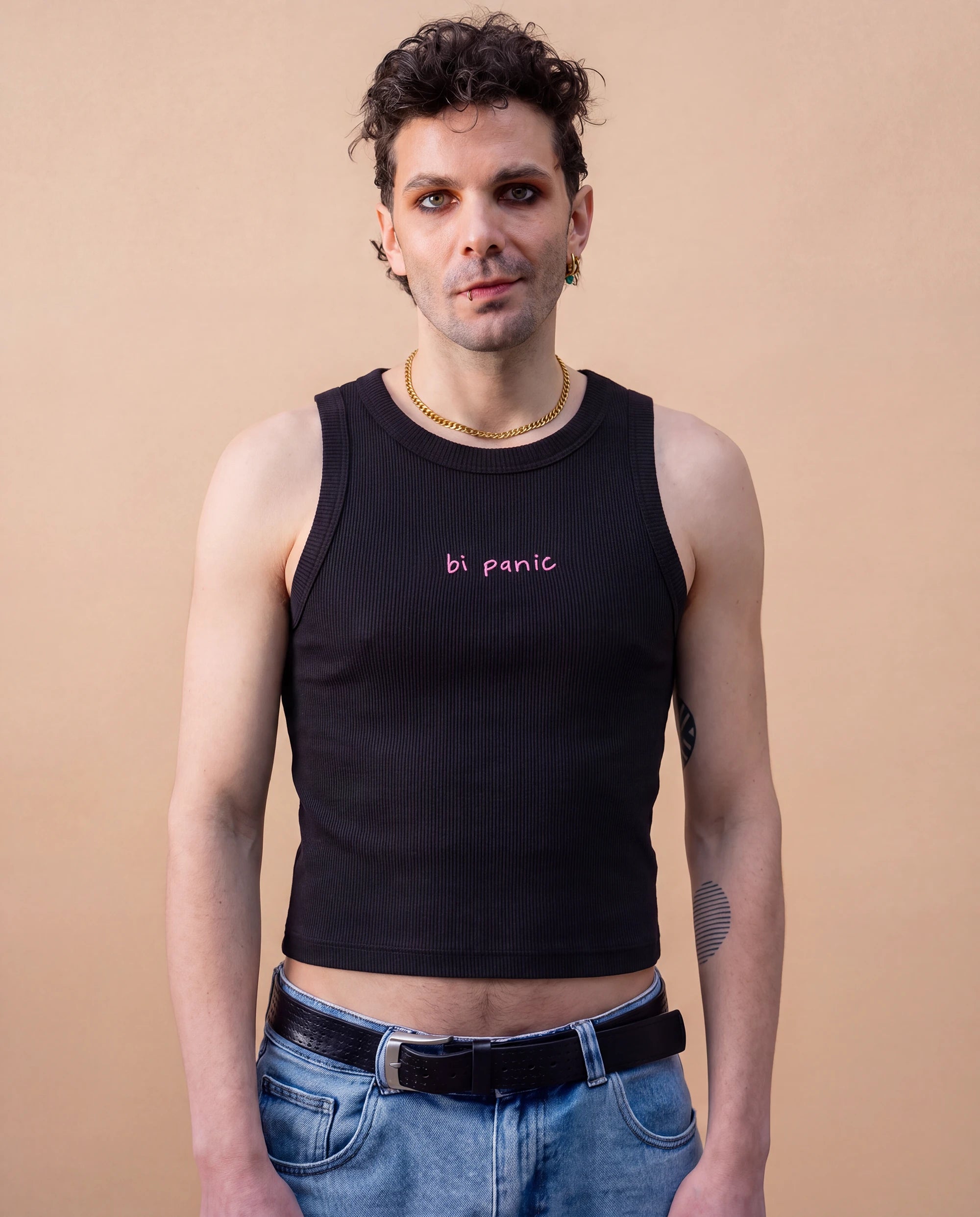 Model wearing a black Biweekly tank top with pink ‘bi panic’ text, front view against a beige background