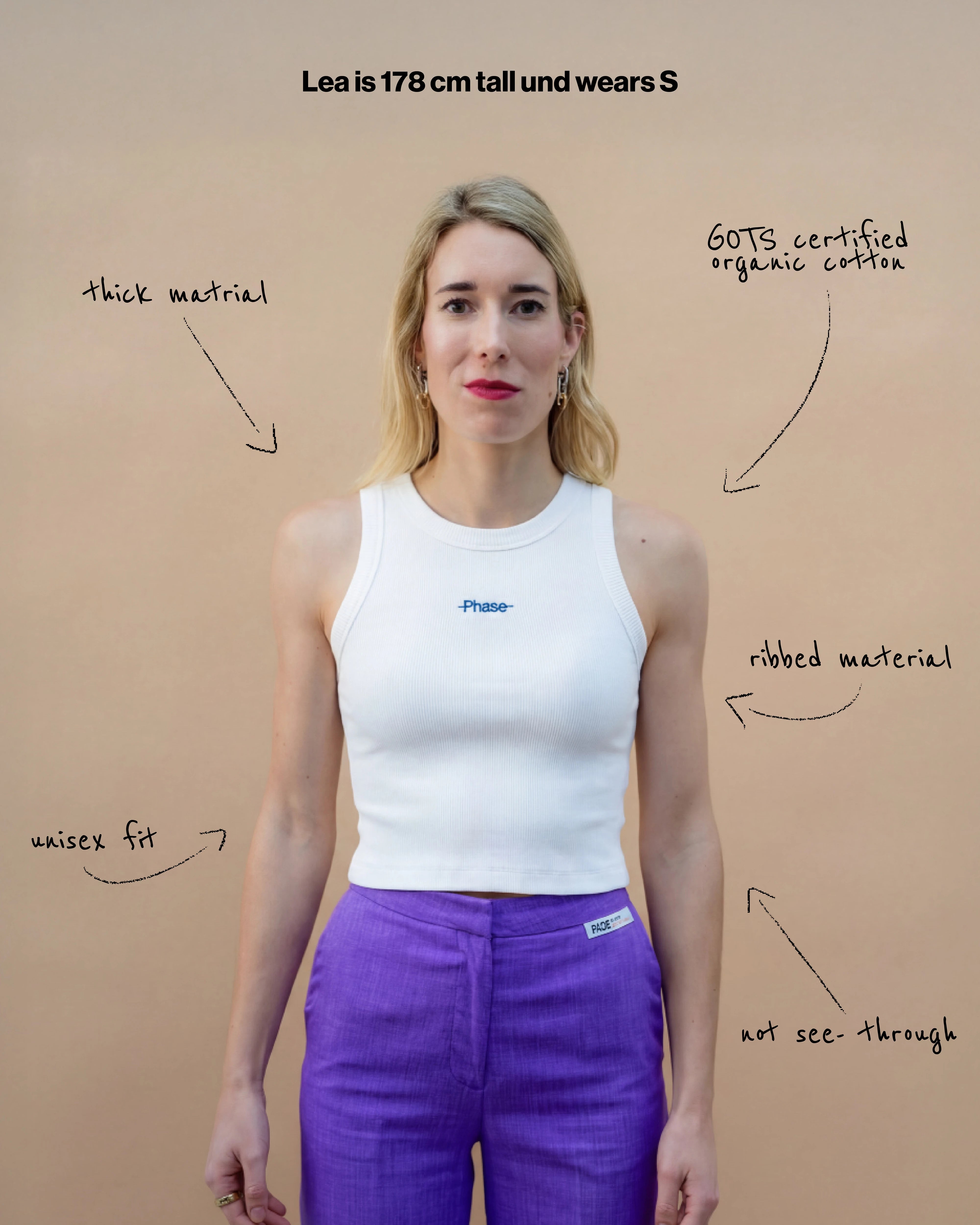 Model wearing a white Biweekly tank top with blue ‘Phase’ text that is crossed out, front view against a beige background. Text that gives information about top. 